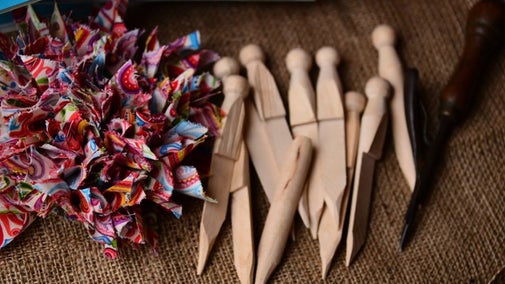 Cut rags poking out of a hessian background, wooden poking tools for rag rugging.